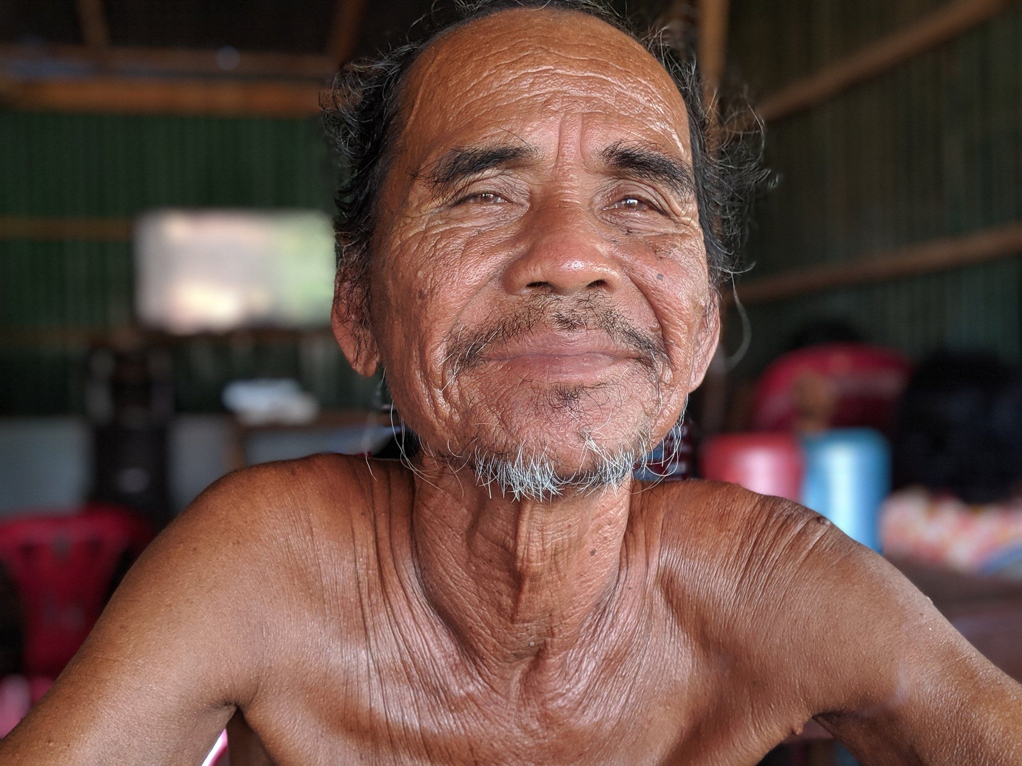 Portrait of an elderly Kampot man smiling inside his home