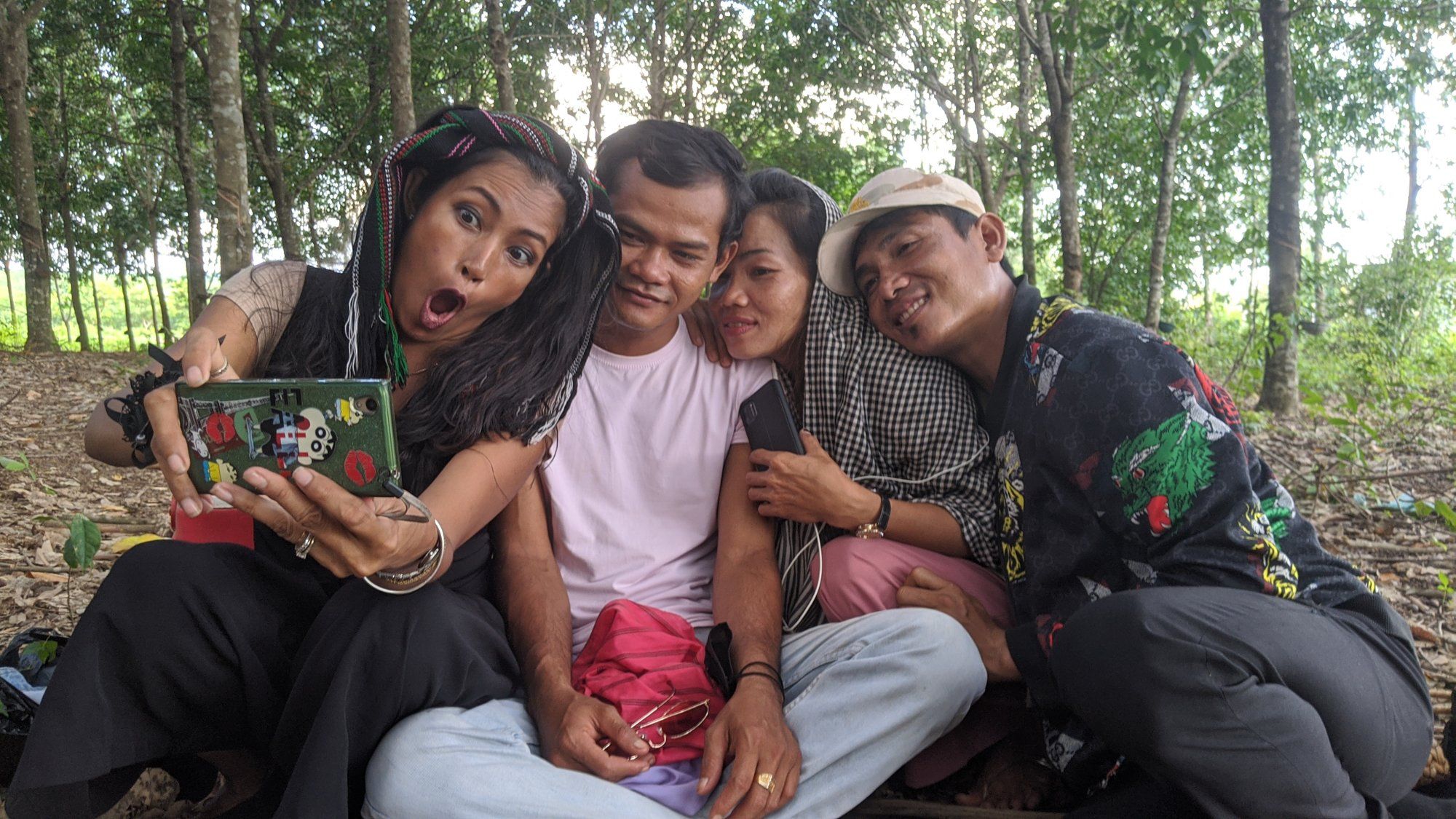 A group of Cambodian friends laughing together over a selfie